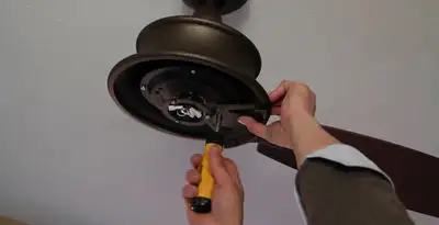 Electrician installing ceiling fan mounting bracket and fixture in Bradenton, FL