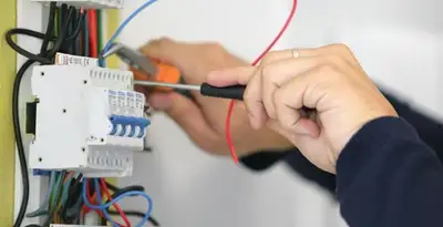 Electrician installing and adjusting circuit breakers in an electrical panel in Bradenton, FL