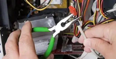 Licensed electrical contractor performing electrical repair with tools in Bradenton Beach, FL