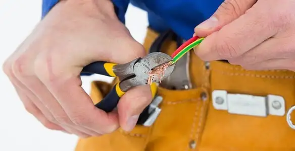 licensed electrician securing electrical wiring with professional tools during service work in Bradenton, FL