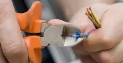 licensed electrician performing precise wire cutting and preparation during electrical service in Bradenton, FL
