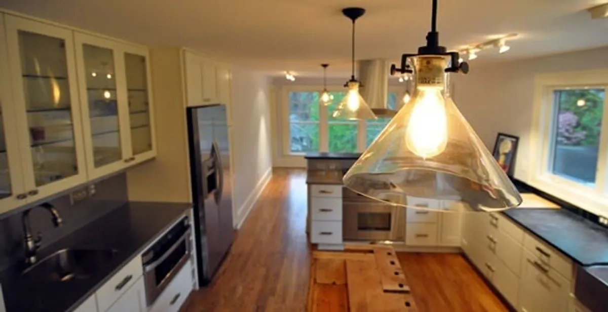 Residential electrician installing modern indoor light fixture in a home in Bradenton, FL