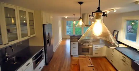 Residential electrician installing modern indoor light fixture in a home in Bradenton, FL