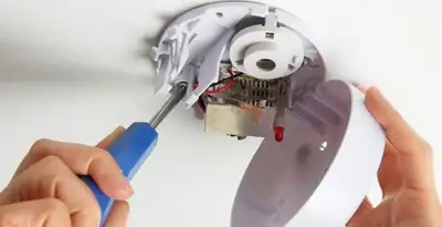 Certified technician wiring smoke detector during installation in Bradenton, FL